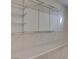 An empty closet features multiple white racks and bars at 1534 Waterford Falls Ave, Las Vegas, NV 89123