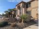 Close up shot of a tan home with unique rock and desert plant landscaping at 1534 Waterford Falls Ave, Las Vegas, NV 89123