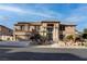 Two-story tan home featuring a front-facing two car garage and well-manicured front yard at 1534 Waterford Falls Ave, Las Vegas, NV 89123