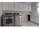 Modern laundry room with stainless steel washer and dryer and convenient upper cabinets at 1534 Waterford Falls Ave, Las Vegas, NV 89123