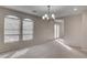 Carpeted living room with modern chandelier lighting and view to the hallway at 1534 Waterford Falls Ave, Las Vegas, NV 89123