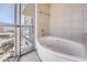 Modern bathroom features a soaking tub, tile surround, and a large window at 200 W Sahara Ave # 2108, Las Vegas, NV 89102