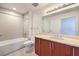 Bright bathroom featuring a clean tiled floor, vanity, soaking tub and modern fixtures at 200 W Sahara Ave # 2108, Las Vegas, NV 89102