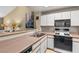 View of the kitchen featuring neutral countertops, white cabinetry, and modern appliances at 260 E Flamingo Rd # 311, Las Vegas, NV 89169