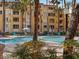 Beautiful community pool with palm trees, lounge chairs, and apartment buildings in the background at 260 E Flamingo Rd # 311, Las Vegas, NV 89169