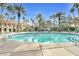 Beautiful community pool surrounded by palm trees and lounge chairs on a sunny day at 260 E Flamingo Rd # 311, Las Vegas, NV 89169