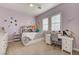 Bright, cheerful bedroom featuring a daybed, desk, and large windows with shutters at 2796 Rosenhearty Dr, Henderson, NV 89044