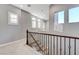 Bright hallway featuring large windows, carpet floors, and elegant stair railing at 2796 Rosenhearty Dr, Henderson, NV 89044