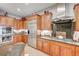 Gourmet kitchen featuring wood cabinetry, stainless steel appliances, granite counters, and stone backsplash at 2796 Rosenhearty Dr, Henderson, NV 89044