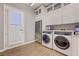 Well-equipped laundry room with front-load washer/dryer, wine refrigerator and ample cabinet space at 2796 Rosenhearty Dr, Henderson, NV 89044