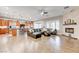 Spacious living room with a brick fireplace, hardwood floors, and an adjacent open-concept kitchen at 2796 Rosenhearty Dr, Henderson, NV 89044