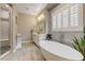 Bright main bathroom featuring a soaking tub, glass shower, and elegant lighting at 2796 Rosenhearty Dr, Henderson, NV 89044