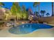 Backyard swimming pool with a rock waterfall feature, surrounded by lush landscaping and privacy walls at 2796 Rosenhearty Dr, Henderson, NV 89044