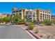 Beautiful condo building with mature landscaping and ample parking on a sunny day at 29 Montelago Blvd # 205, Henderson, NV 89011