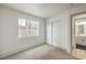 A cozy bedroom with carpeted floors, a large window for natural light, and a closet with sliding doors at 2921 Moonlight Bay Ln, Las Vegas, NV 89128