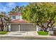 Charming two-story home featuring a tile roof, a two-car garage, and lush landscaping at 2921 Moonlight Bay Ln, Las Vegas, NV 89128