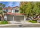 Charming two-story home featuring a tile roof, a two-car garage, and lush landscaping at 2921 Moonlight Bay Ln, Las Vegas, NV 89128