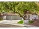 Charming single-story home featuring a tile roof, a two-car garage, and mature tree at 2921 Moonlight Bay Ln, Las Vegas, NV 89128