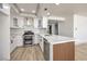 Modern kitchen with stainless appliances, white cabinets, quartz counters, and unique vertical wood backsplash at 2921 Moonlight Bay Ln, Las Vegas, NV 89128