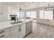 Modern kitchen with stainless appliances, white cabinets, quartz counters, and view to the backyard at 2921 Moonlight Bay Ln, Las Vegas, NV 89128