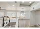 Modern kitchen features stainless steel sink, white cabinets, and view to the backyard at 2921 Moonlight Bay Ln, Las Vegas, NV 89128