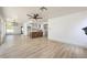 Spacious living room showcasing hardwood floors, white walls, modern lighting and partial kitchen view at 2921 Moonlight Bay Ln, Las Vegas, NV 89128