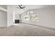 Spacious living room with a fireplace, ceiling fan, and large windows providing ample natural light at 2921 Moonlight Bay Ln, Las Vegas, NV 89128