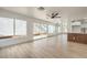 Open living space featuring wood floors, white walls, many windows, and a partial view of the kitchen at 2921 Moonlight Bay Ln, Las Vegas, NV 89128