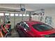 Organized garage featuring a red car, storage cabinets, and an automatic door opener at 3157 Faiss Dr, Las Vegas, NV 89134