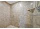 Close up of the walk-in shower featuring custom stone tile, a shower head, and a built in shelf at 360 E Desert Inn Rd # 602, Las Vegas, NV 89109