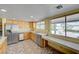 Well-lit kitchen boasting stainless steel appliances, wood cabinets, a breakfast bar, and a view of the backyard at 3716 N Torrey Pines Dr, Las Vegas, NV 89108