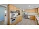 Open-concept kitchen featuring stainless steel appliances, wood cabinetry, and a seamless flow for modern living at 3716 N Torrey Pines Dr, Las Vegas, NV 89108