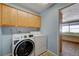 Laundry room with a modern washer and dryer, complemented by overhead cabinets for storage at 3716 N Torrey Pines Dr, Las Vegas, NV 89108