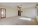 Spacious living room featuring neutral carpet, ceiling fan, and natural light from a window and glass paneled door at 3716 N Torrey Pines Dr, Las Vegas, NV 89108