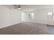 Open living room featuring neutral carpet, ceiling fan and large windows for ample natural light at 4215 Gold Desert St, North Las Vegas, NV 89032