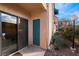 View of building exterior with sliding glass door, a teal door and landscaping at 4425 Woodpine Dr # 104, Las Vegas, NV 89119