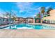 Community pool with clear blue water, shaded seating area, and manicured landscaping at 4425 Woodpine Dr # 104, Las Vegas, NV 89119