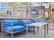 Modern patio featuring blue cushioned chairs, silver tables, and palm trees near the pool at 4575 Dean Martin Dr # 505, Las Vegas, NV 89103