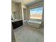 Elegant bathroom featuring a freestanding tub, large window, and vanity with dark wood cabinets at 4630 Blushing Dawn Ave, Las Vegas, NV 89118