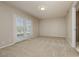 Bright bedroom with neutral carpet, light walls, a bathroom, and a door to the backyard at 4666 Amberwood Ln, Las Vegas, NV 89147