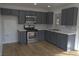 Modern kitchen featuring gray cabinetry, stainless steel appliances, and beautiful backsplash at 4816 Greencreek Dr, Las Vegas, NV 89110