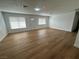 Spacious living room featuring sleek wood floors, white walls, modern lighting, and natural light at 4816 Greencreek Dr, Las Vegas, NV 89110