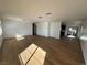 Spacious living room featuring sleek wood floors, white walls, and modern lighting at 4816 Greencreek Dr, Las Vegas, NV 89110