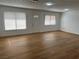 Spacious living room featuring sleek wood floors, white walls, modern lighting, and natural light at 4816 Greencreek Dr, Las Vegas, NV 89110