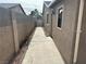 Narrow side yard with a concrete walkway and a view of a gate leading to the backyard at 4816 Greencreek Dr, Las Vegas, NV 89110