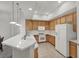 Kitchen featuring light wood cabinets, white appliances, and a breakfast bar at 50 E Serene Ave # 123, Las Vegas, NV 89123