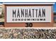 Entrance sign for Manhattan Condominiums, displaying the community's name and address number at 50 E Serene Ave # 123, Las Vegas, NV 89123