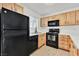 Well-lit kitchen features wood cabinetry, black appliances and laminate countertops at 5394 Swenson St # 29, Las Vegas, NV 89119