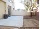 View of the backyard with a concrete patio, rock landscaping and block wall at 5490 Floating Flower Ave, Las Vegas, NV 89139