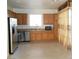 Spacious kitchen with stainless steel appliances, wood cabinets, granite countertops, and modern vinyl flooring at 5490 Floating Flower Ave, Las Vegas, NV 89139